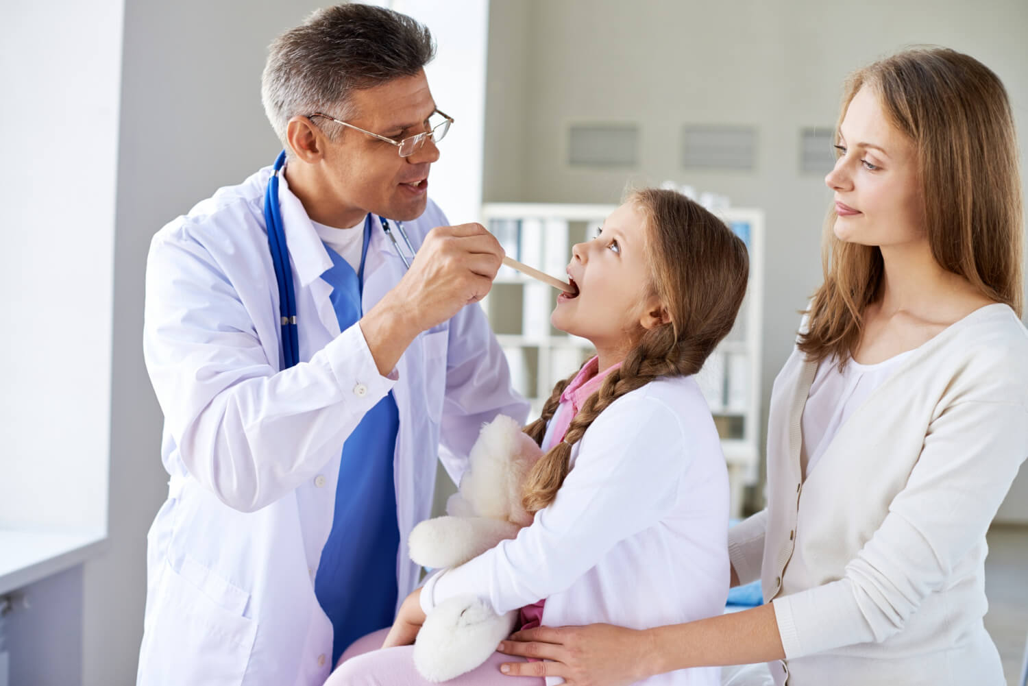 Doctor examining little girl Doctor examining a young girls tonsils and adenoids