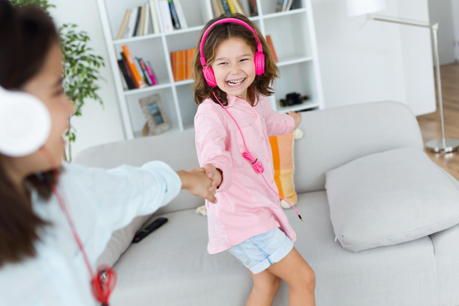 young sisters listening to music and dancing
